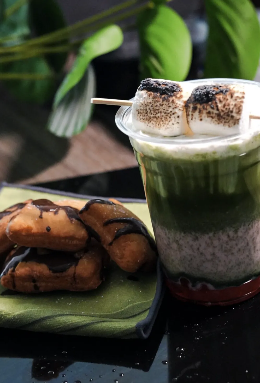 Layered chia and matcha parfait served with toasted marshmallows and chocolate pastries