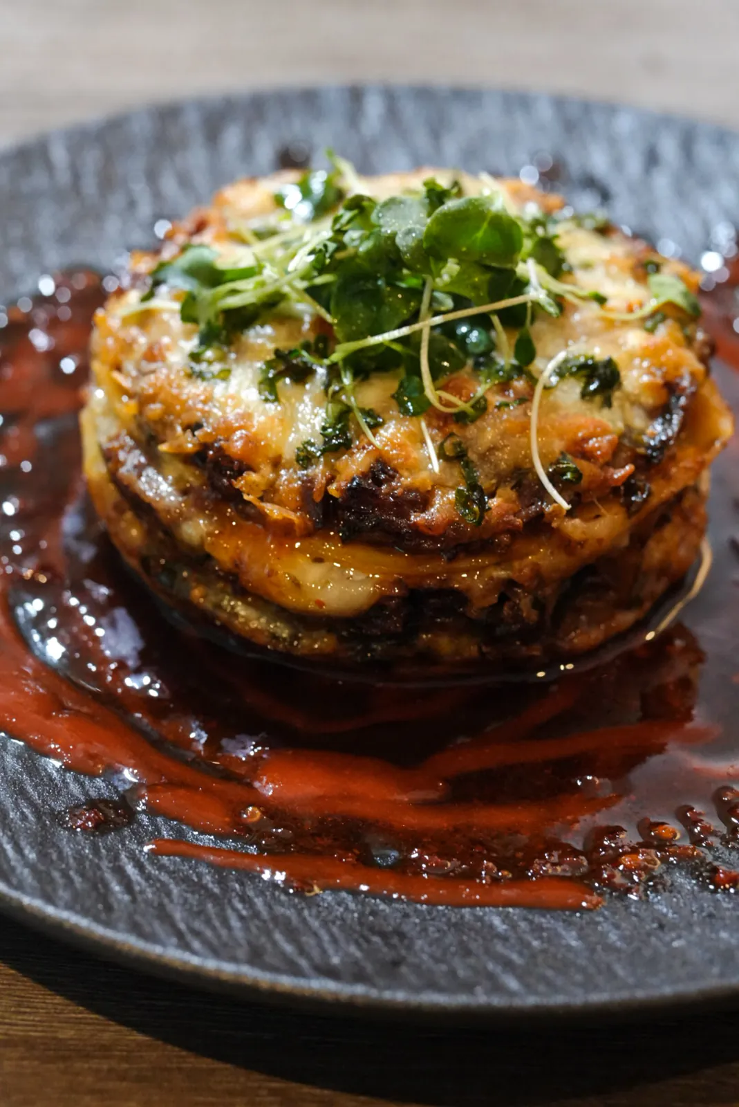 FloJoe's layered savory stack finished with watercress and chili-berry reduction