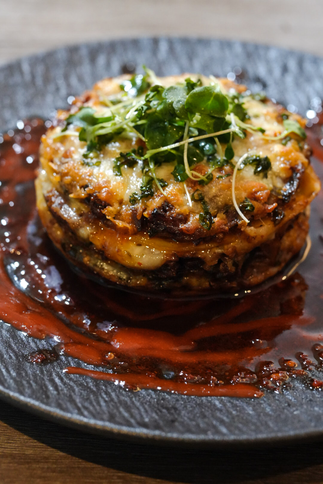 FloJoe's layered savory stack finished with watercress and chili-berry reduction