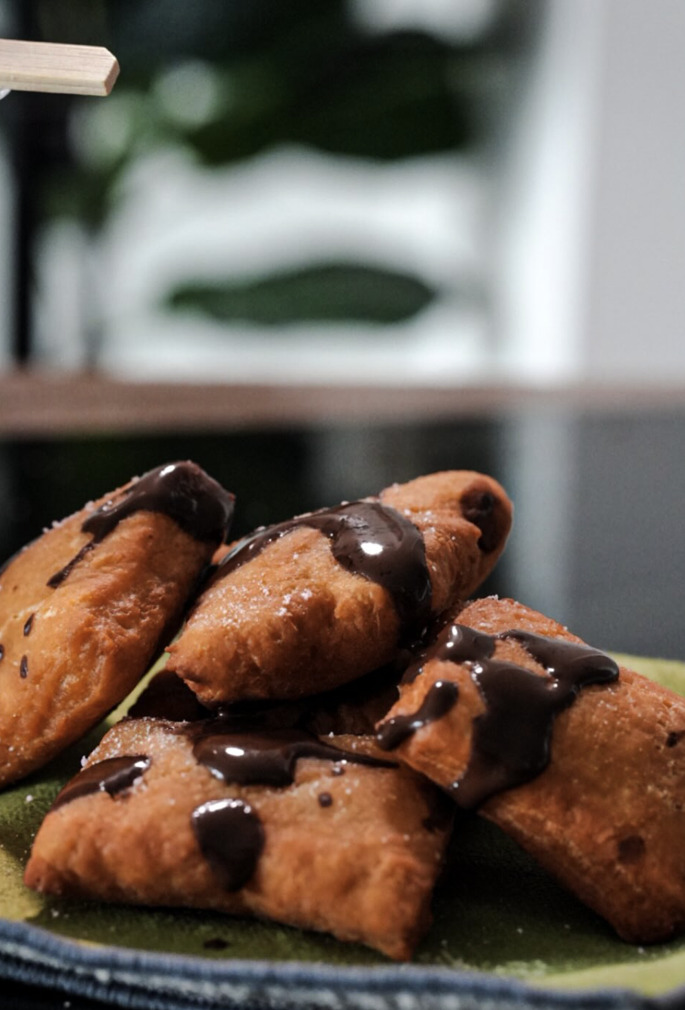 Golden puff pastries drizzled with glossy chocolate sauce