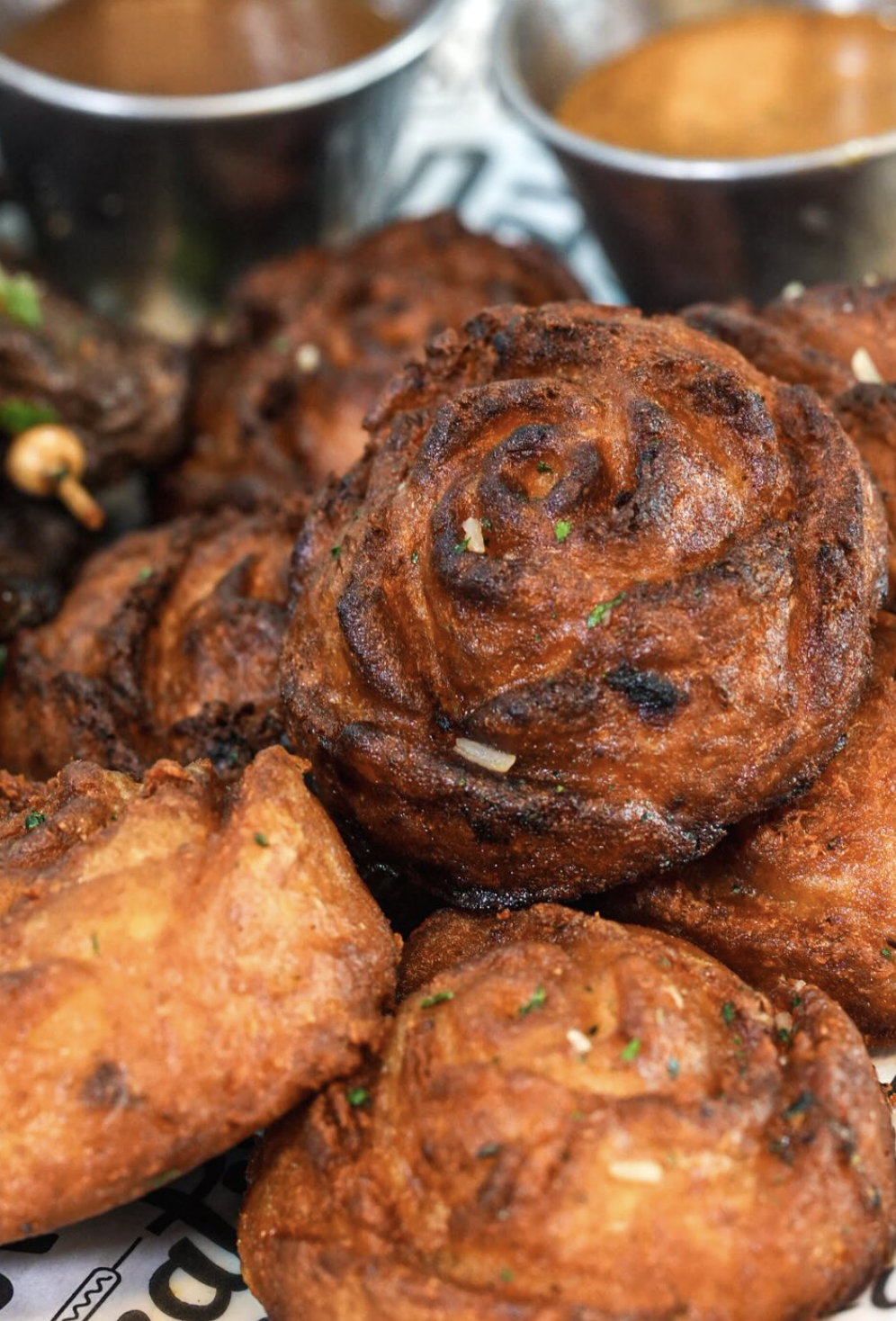 Rose-shaped puff puff with dipping sauces in the background