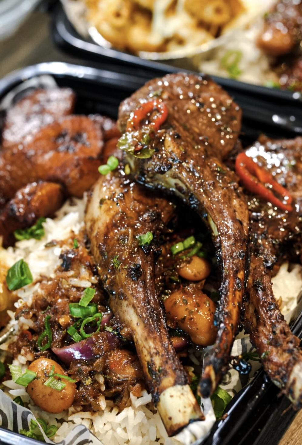 Braised lamb chops over rice with peppers, tomatoes, and herbs